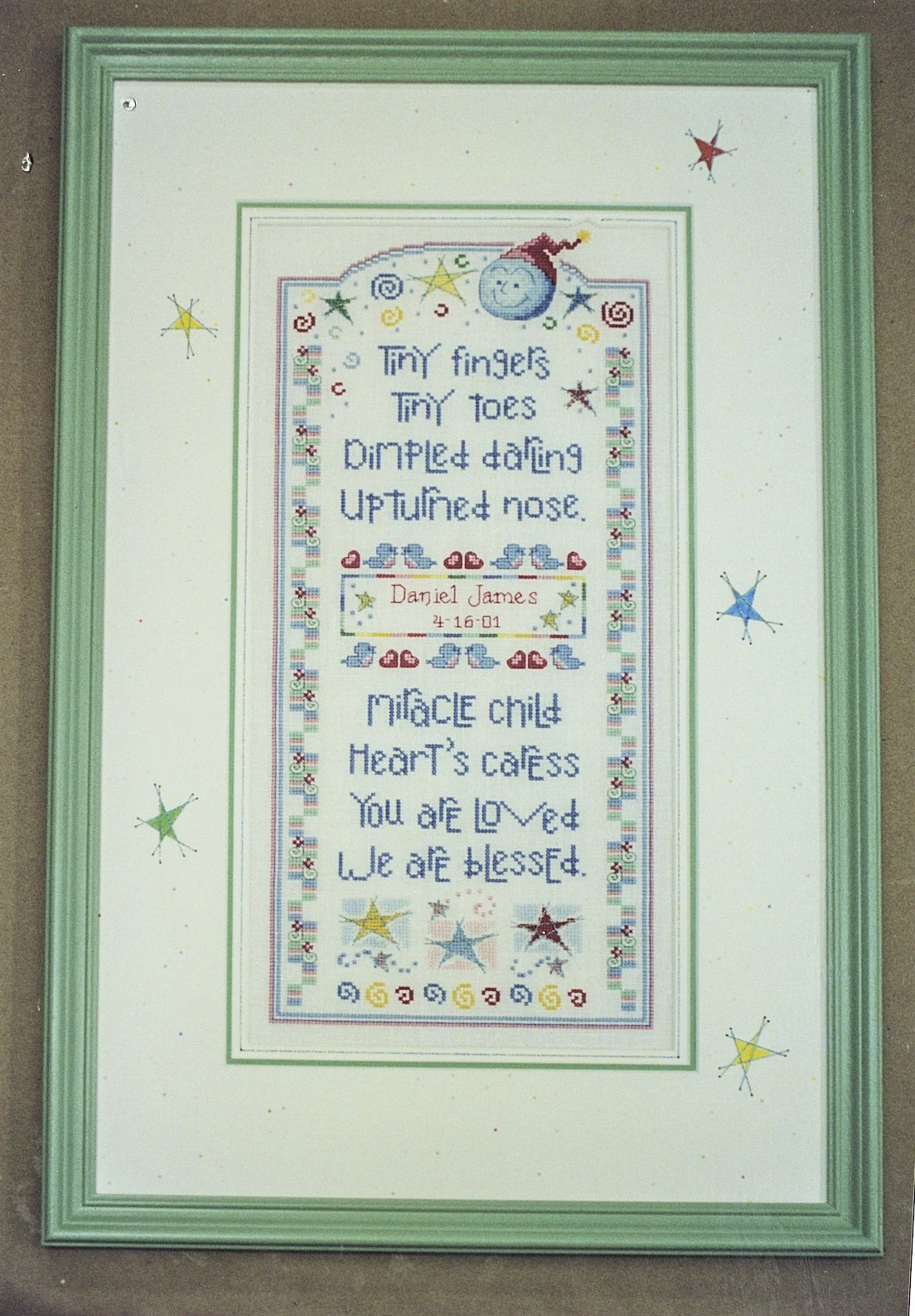 framed Baby sampler with stars cross stitched with hand embellished mat